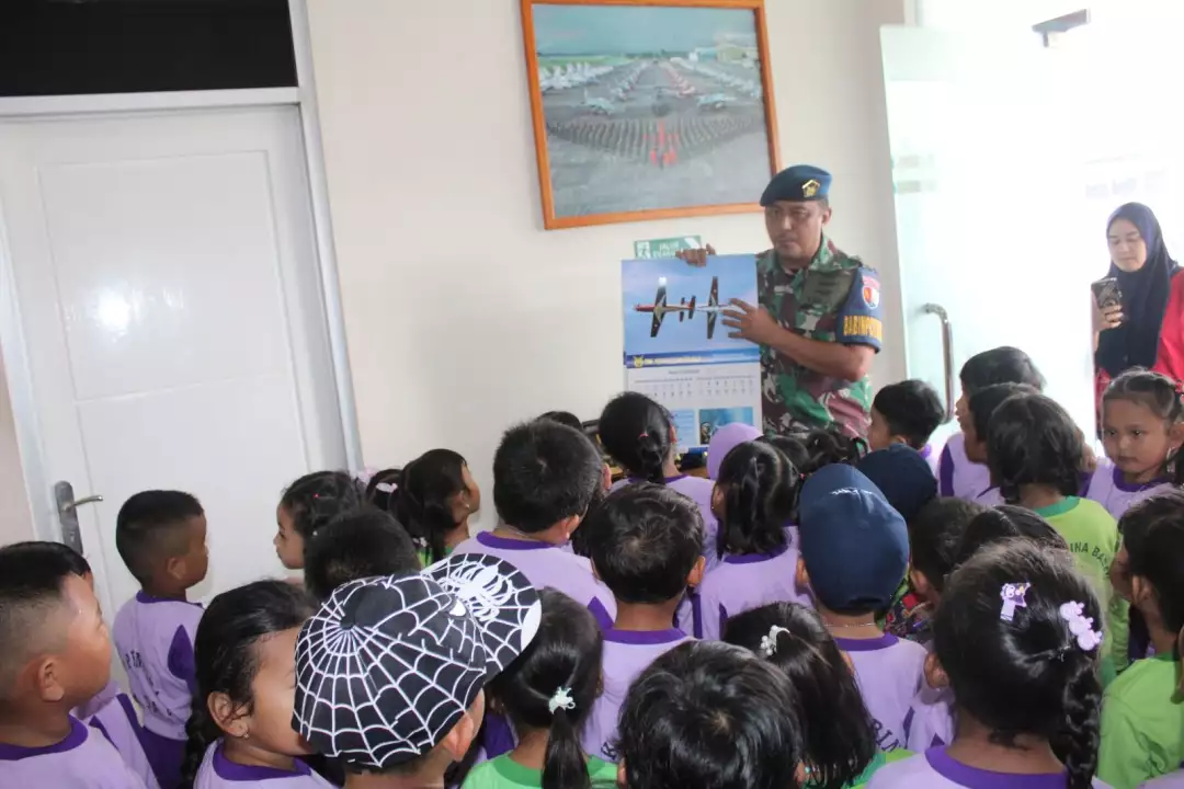 Prajurit TNI AU memberikan edukasi mengenal pesawat terbang kepada anak-anak sekolah